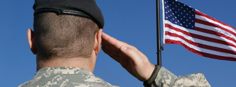 Man in military uniform saluting to American flag